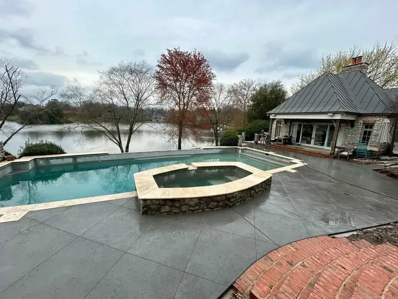 Broom-finish concrete pool deck with stone borders at a Lake Norman home | Old North Concrete Co.